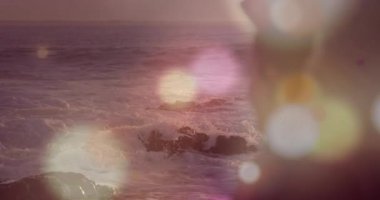 Güneş ışıldıyor, atkısı olan kadın sahile bakıyor sürüklenen ufuk küreleri turizm reklamı yapıyor. Romantik, sakin, manzaralı, yansıtıcı, ruhani, barışçıl, doğa