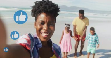 Telefonu tutan, plaj aile selfie 'si çeken, yüzen sosyal başparmak kaldırma simgeleri biriktiren bir kadın. Eğlence, bağlantı, eğlence, açık hava, coşku, birlik, mutluluk