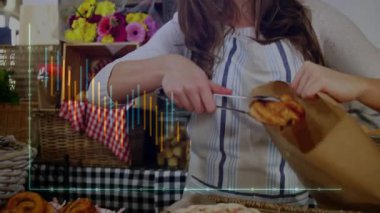 Kadın satıcı çantasına uzanıyor ve pastaneye maşayla maşa yerleştiriyor. Sanatçı, sıcak, köylü, fırın, el yapımı, rahat, yerli