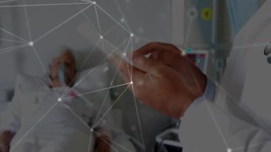 Kıdemli hekim tableti tıkırdatıyor ve analiz etmek için tıbbi izleme üzerinde parlayan veri şebekesi gösteriyor. Tıbbi, sağlık, teletıp, dijital, veri, profesyonel, teknoloji