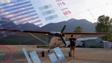 Pilot akıllı telefonu pervane uçağında dinliyor. Veri kaplamasını etkinleştiriyor ve gösterge paneline aktarıyor. Havacılık, analitik, teknoloji, veri görselleştirme, dağ manzarası, uzaktan izleme, uçak operasyonu