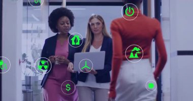 Yürüyen iki iş kadını dizüstü bilgisayardaki ölçümleri analiz ederken yüzen enerji simgelerinin ortaya çıkmasına neden oluyor. Profesyonel, takım çalışması, yenilik, çevre, sürdürülebilirlik, modern, kurumsal