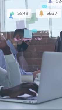 Zeka telefonu kullanan Afro-Amerikan maskeli adam üzerinden simge ve numaraların animasyonu. Küresel sosyal medya, iş dünyası, bulut hesaplama ve veri işleme kavramı dijital olarak oluşturulmuş video.