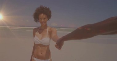 Kadın plajda, turizm reklamı için mercek altında el ele tutuşarak yürüyor. Manzara, romantizm, eğlence, açık hava, canlı, dinginlik, arkadaşlık.