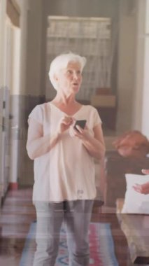 Neşeli bir şekilde dans eden yaşlı bir çift evlerinin parlak koridorunda animasyonun tadını çıkarıyorlar. Yaşlılar, mutluluk, yaşam tarzı, dans, oturma odası, hareket