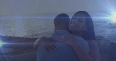 Bir kadın, seyahat reklamı için kıyı üstüne kıyı adamı kucaklıyor. Romantizm, samimiyet, günbatımı, dinginlik, bağlantı, duygusal, uyum