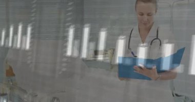 Kadın doktorun dosyaya bakması parmaklıkların yükselmesine ve EKG 'nin sağlık kontrolüne yol açmasına neden oluyor. Tıbbi, sağlık, teşhis, teknoloji, profesyonellik, klinik, veri