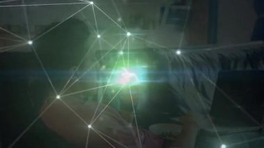 Adam evinde bardak yudumluyor ve dizüstü bilgisayarda yazıyor. Gelişmeyi gösteren titreşimli teknoloji ağı üretiyor. Teknoloji, bağlantı, dijital, yenilik, çalışma alanı, modern, ilham