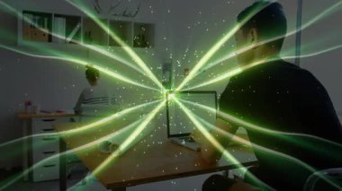 İş arkadaşları ofis toplantısında teknik demo için dizüstü bilgisayarı inceliyor, yeşil kirişler masa dolduruluyor. Teknoloji, işbirliği, yenilik, gelecek, çalışma alanı, dijital, yaratıcı