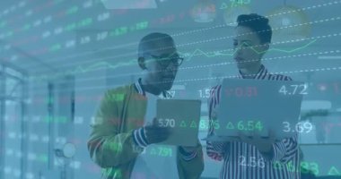 Bilgi incelemesi için ofisteki stok verilerini güncellerken, tableti tıklatan ve laptopu eğen profesyoneller. İş, işbirliği, teknoloji, analiz, finans, çalışma alanı, yenilik