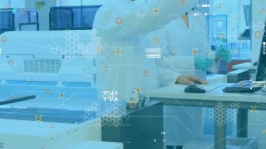 Tıbbi teknisyenler numuneyi analiz cihazına yerleştiriyor, monitördeki grafikleri gösteriyor, analizleri doğruluyor. Laboratuvar, araştırma, işbirliği, kesinlik, teknoloji, analiz, bilimsel