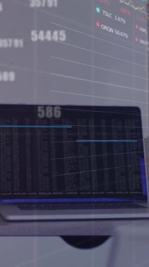 Ofisteki dizüstü bilgisayarın üzerinde numaralar, grafikler, takas panoları değiştirme animasyonu. Dijital bileşik, çoklu pozlama, rapor, iş dünyası, borsa, büyüme ve teknoloji kavramı.