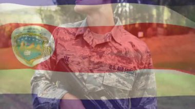 Kamuflaj üniformalı bir USAF üyesi tüfeği ayarlıyor, sola bakıyor, Kosta Rika bayrağıyla tarama yapıyor. Askeri, savunma, disiplin, boru hattı, eğitim, taktik, vatanseverlik