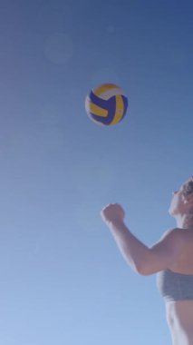 Deniz kenarında plaj voleybolu oynayan beyaz kadının üzerinde parlayan ışıkların canlandırması. Egzersiz, refah, spor, açık hava yaşam tarzı, yaz ve tatil konsepti dijital olarak oluşturulmuş video.