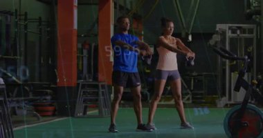 Spor salonunda dayanıklılık kazanmak için kalça menteşesinde kettlebell sallamasını başlatan iki antrenman partneri. Fitness, strength, training, Jimnastik, motion, team work, enerjik