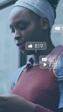 Akıllı telefon kullanan Afrikalı Amerikalı bir kadının medya simgelerinin canlandırılması. Sosyal medya, yaşam tarzı ve dijital arayüz konsepti dijital olarak oluşturulmuş video.