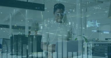 Ofis masasında dizüstü bilgisayarla, bitki ve masa lambasıyla finansal haritaları inceleyen adam. İş, profesyonel, teknoloji, analitik, çalışma alanı, yenilik, üretkenlik