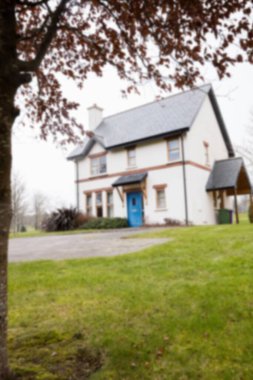 Gökyüzüne karşı çimenliği olan beyaz ev