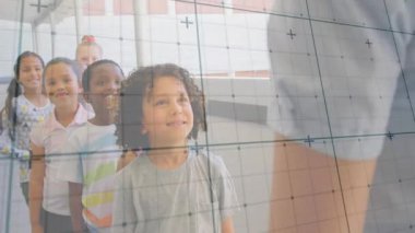 Eğitim öğretmeni, öğrencilere koridorun aşağısında kapı eşiğine doğru giderken el kol hareketi yaparak rehberlik ediyor. Sınıf, danışmanlık, liderlik, öğrenme, rehberlik, takım çalışması, çeşitlilik