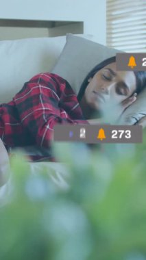 Medya ikonlarının kanepede uyuyan kadın üzerindeki canlandırması. Sosyal medya ve dijital arayüz konsepti dijital olarak oluşturulmuş video.