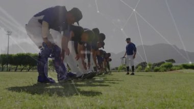 Oyuncular beysbol antrenmanında ağ takibi ile bacak esnetirken koç yürüyüş hattı. Atletizm, takım çalışması, fitness, açık hava, eğitim, yenilik, disiplin