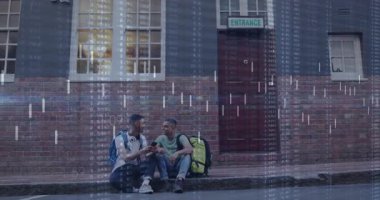 İki arkadaş kaldırımda oturmuş akıllı telefonları tarıyor ve şehir manzarasını kaplayan finans haritalarını aktifleştiriyor. Kentsel, dostluk, teknoloji, veri görselleştirme, gündelik, modern, yenilik