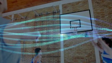 Gri formalı bir pas oyuncusu basketbol salonunda ışık çizgileri ile sayı atarken. Eylem, rekabet, gençlik, fitness, eğitim, enerji, dinamik