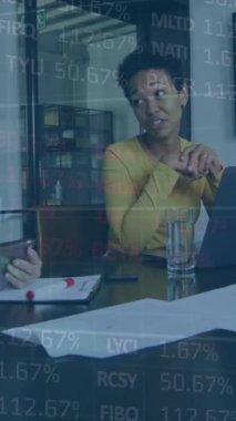 Animation of graphs and trading board over diverse female coworkers discussing report on laptop. Digital composite, multiple exposure, stock market, business, teamwork, office and technology concept.