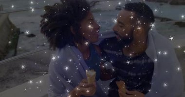 Oturan bir çift, gözleri kenetlenmiş yıldız çıkmalarını kutlamak için kozalakları paylaşıyorlar. Romantizm, samimiyet, bağlantı, kıyı şeridi, alacakaranlık, şehvet, şefkat