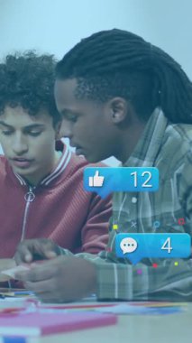 Masada iş birliği yapan genç yetişkinler sosyal medya simgeleriyle animasyonu tartışıyor. Takım çalışması, beyin fırtınası, yaratıcılık, dijital iletişim, tartışma, işbirliği