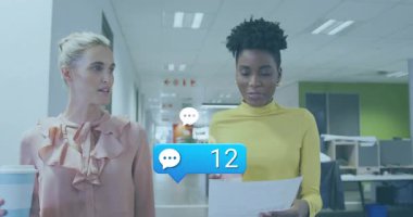 İki iş akranı, sohbet ikonu yorumlarının konfetiyle tırmandığını izleyerek teftiş raporunu inceliyor. İşbirliği, takım çalışması, ofis, iletişim, profesyonel, gündelik, üretkenlik