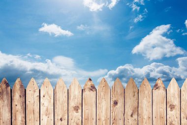 Tahta çitler düz dizayn boyunca uzanıyor parlak mavi gökyüzünün altında beyaz bulutlarla. Kırsal, doğal, pastoral, açık hava, canlı, manzara, sınır