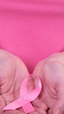 Kafkasyalı bir kadının pembe kanser farkındalığı kurdelesi taşıdığı bir video. Göğüs kanseri pozitif farkındalık kampanyası konsepti.