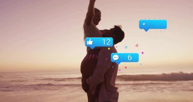 Erkek, gün batımında sörf yaparken kadını kaldırıyor sosyal medya simgelerini sürüklemeye başlıyor. Nişanı takip ediyor. Romantik, sevgi, bağlantı, siluet, günbatımı, ahenk, pozitiflik