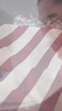 Arka plan animasyonunda şehir silueti olan insanların üzerine Amerikan bayrağı sallıyor. Vatanseverlik, ABD, bağımsızlık, özgürlük, kutlama, gurur