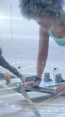 Reform makineleri üzerinde egzersiz yapan kadınlar animasyon için dijital arayüz kullanıyor. Egzersiz, fitness, pilates, teknoloji, spor, egzersiz