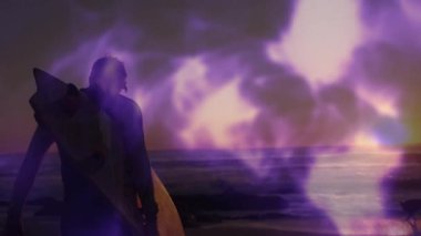 Sudan çıkan sörfçü, gün batımını takdir eden mor alevlerin arasında kuma basıyor. Deniz kenarı, macera, sükunet, siluet, doğa, rahatlık, açık hava