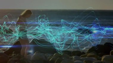 Kayalık taşlara basan bir kadın ve teknoloji gösterisinde neon-mavi dalga görüntüsünü başlatan bir kadın. Enstrümantasyon, manzara, dijital, fütürizm, dinginlik, doğa, yenilik