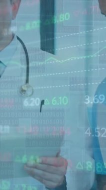 Animation of trading board and graphs over diverse senior doctor explaining coworkers over tablet. Digital composite, multiple exposure, medical, healthcare, investment, report, teamwork, technology.