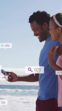 Sahilde selfie çeken çiftin sosyal medya etkileşimi. Tatil, dijital, yaz, seyahat, teknoloji, mobil