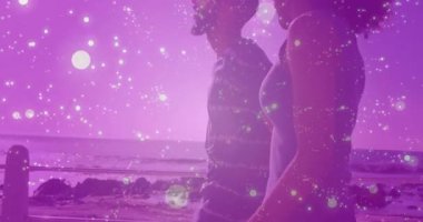 Gün batımında sahil kenarına yaklaşan çift, seyahat için kıyı şeridini kaplayan ışık parçacıkları gibi yürüyor. Romantik, manzara, sükunet, minimalist, macera, huzur, denizcilik