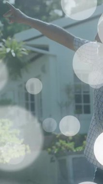 Gökyüzünü gösteren bokeh ışıklı adam ve çocuk evin arka planında animasyon yapıyor. Aile, kaynaşma, gece, açık hava, yıldızlar, merak