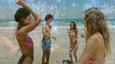 Arkadaşlar müzik dinleyip kollarını kaldırırken okyanus kıyısında seyahat pazarlaması için kalçalarını sallıyorlar. Tatil, eğlence, canlılık, kaygısız, kutlama, manzara, açık hava.