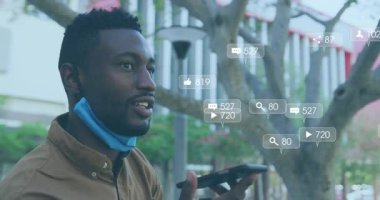 Şehir meydanında akıllı telefona konuşan adam hareketli sosyal ikonlar sergiliyor, tırmanıyor ve düşüyor. Kentsel, teknoloji, iletişim, dijital, sosyal, açık hava, canlı