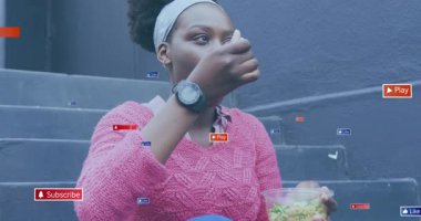 Kadın salatayı kepçeleyerek yüzen simgeleri aktifleştirirken basamaklarda canlı içerik yaratıyor. Sokak, günlük, yaşam tarzı, modern, açık hava, yansıtıcı, nişan