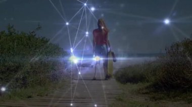 Boogie tahtası taşıyan bir kadın, okyanusa doğru yürürken dijital ağın titremesini tetikliyor. Sahil, teknoloji, açık hava, macera, bağlantı, yaşam tarzı, canlı