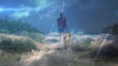 Tahta kaldırımda yürüyen sörf tahtası taşıyan bir kadın kıyı şeridine doğru teknoloji ağını etkinleştiriyor. Sahil, kıyı şeridi, bağlantı, teknoloji, açık hava, yaşam tarzı, macera