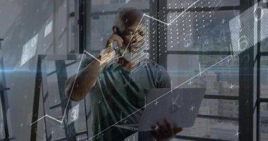 Olgun bir adam akıllı telefonu kulağına kaldırıyor ve elinde dizüstü bilgisayarla konuşuyor ve analitik kaplamaları başlatıyor. Teknoloji, dijital, analitik, yenilik, iş, veri, görselleştirme