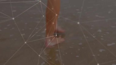 Çıplak ayaklar ayak bileklerinde dönmeye başlıyor ve kıyı boyunca bacak hareketlerini örtüyor. Deniz kıyısı, sükunet, dijital ağ, hareket, dinginlik, minimalist, bağlantı