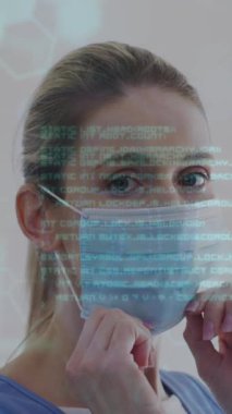 Yüz maskesi olan beyaz bir kadının veri işleme animasyonu. Küresel iş ve dijital arayüz kavramı dijital olarak oluşturulmuş video.